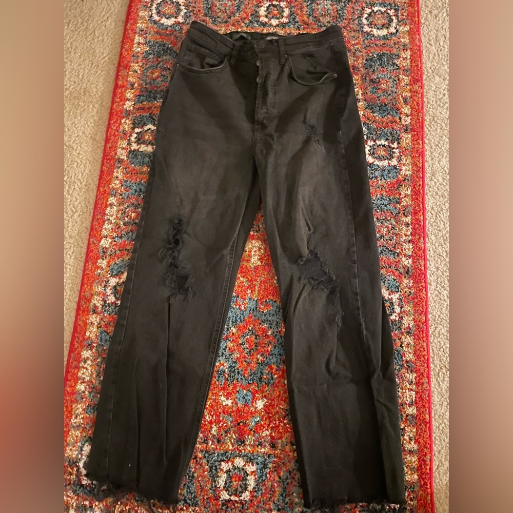 Womens black jeans with holes in the knees and fringed at the bottom. Size 8.
